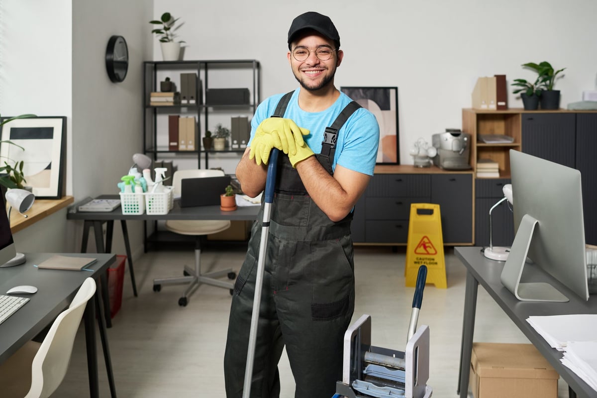 Smiling cleaning professional in uniform at work
